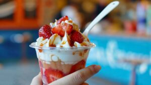 Hand Holding a Strawberry Sundae in an Ice Cream Shop